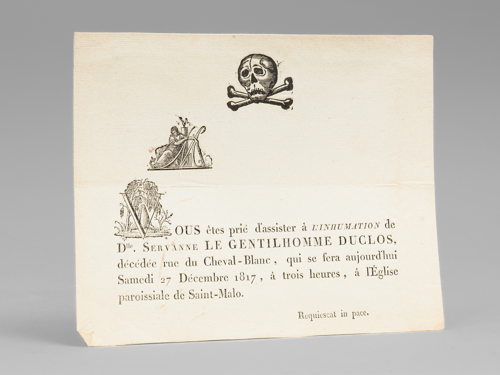 photo n&deg;6 : [ Billet mortuaire malouin imprim&eacute; avec gravure sur bois repr&eacute;sentant un cr&acirc;ne et des tibias entrecrois&eacute;s, all&eacute;gorie de la mort &eacute;teignant la flamme et arbre surplombant la tombe : ] M. Vous &ecirc;tes pri&eacute; d